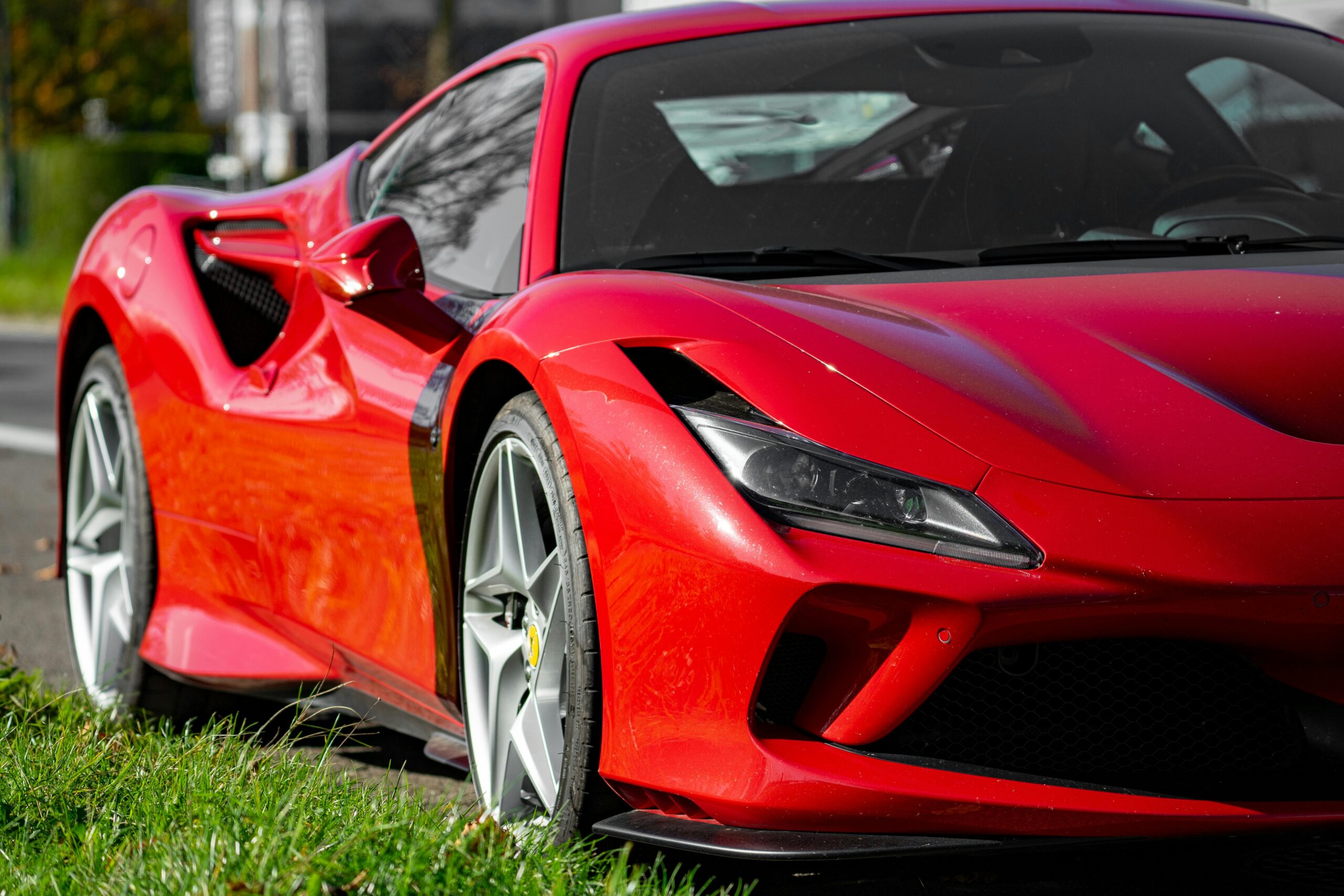 A vibrant red sports car parked on the roadside, showcasing sleek design and modern styling.